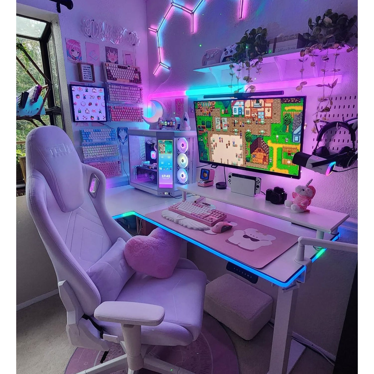 Gaming setup with pink and purple theme, including a chair, desk, and computer equipment.m 