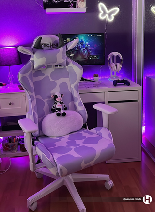 Purple gaming chair in a cute purple gaming setup by @naomiii.nicole. The lavender cow gaming chair on full display with a cute technisport cow plushy sitting on the chair. 