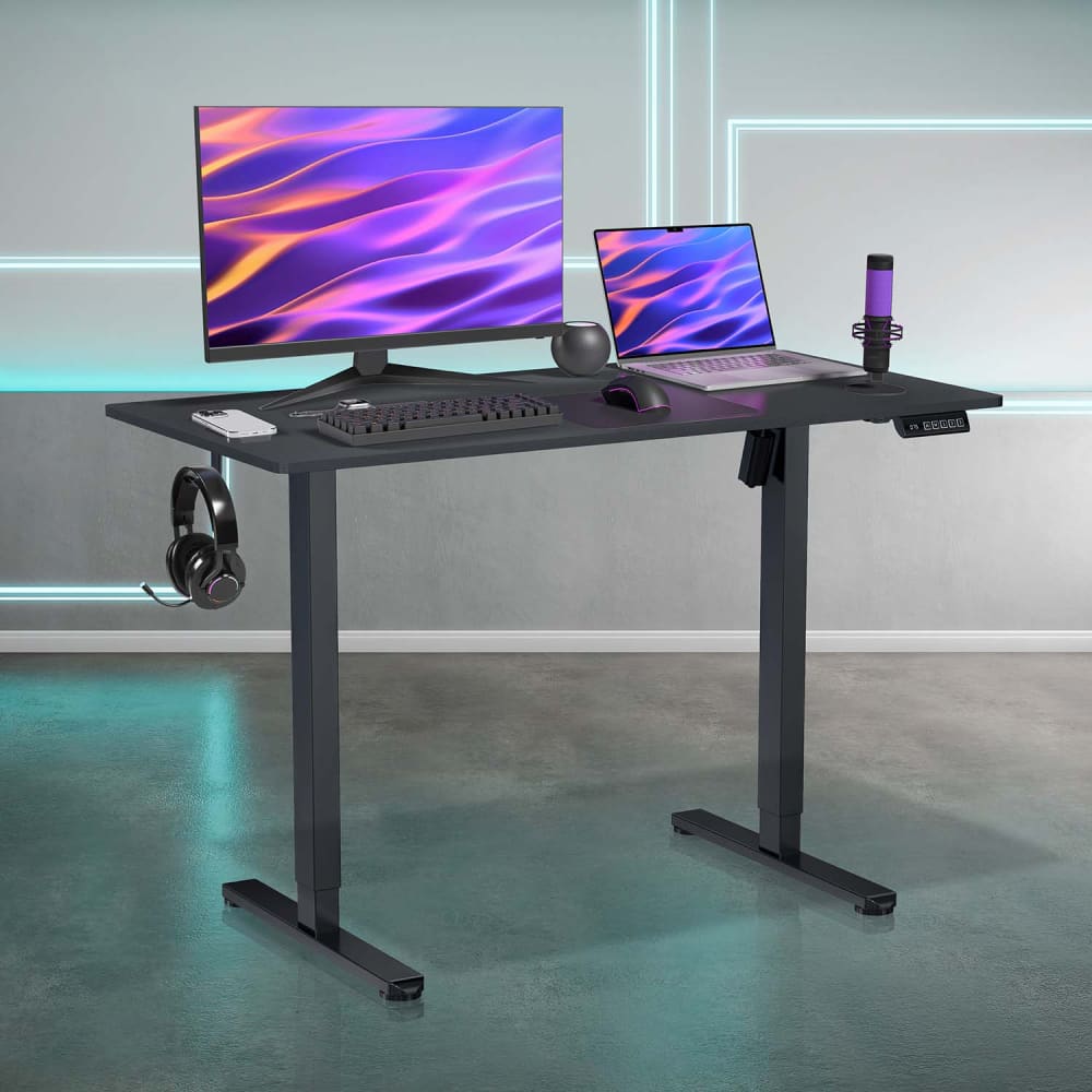 Height-adjustable black desk with computer setup.