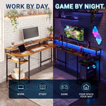 A split-screen promotional image showing a wooden computer desk in two use cases: on the left, 'WORK BY DAY' with a computer, laptop, and keyboard on a white brick wall; on the right, 'GAME BY NIGHT' with a glowing monitor, keyboard, speakers, and ambient blue lighting in a dark room. The desk has a rustic wood top and black metal frame with open shelving. 