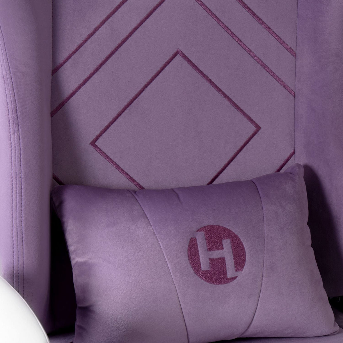 Purple pillow with a logo on a matching purple background 