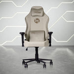 A beige gaming chair with a headrest and lumbar support cushion, featuring black armrests and a five-star base with casters.