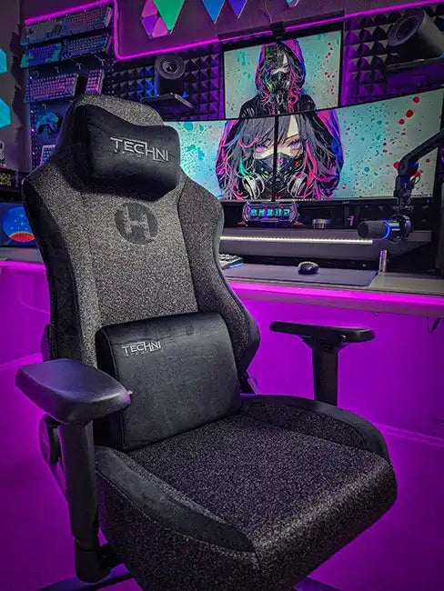 A gray and black upholstered gaming chair with a headrest and lumbar support pillow.