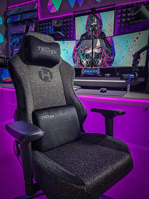 A grey and black gaming chair with a headrest and lumbar support cushion.