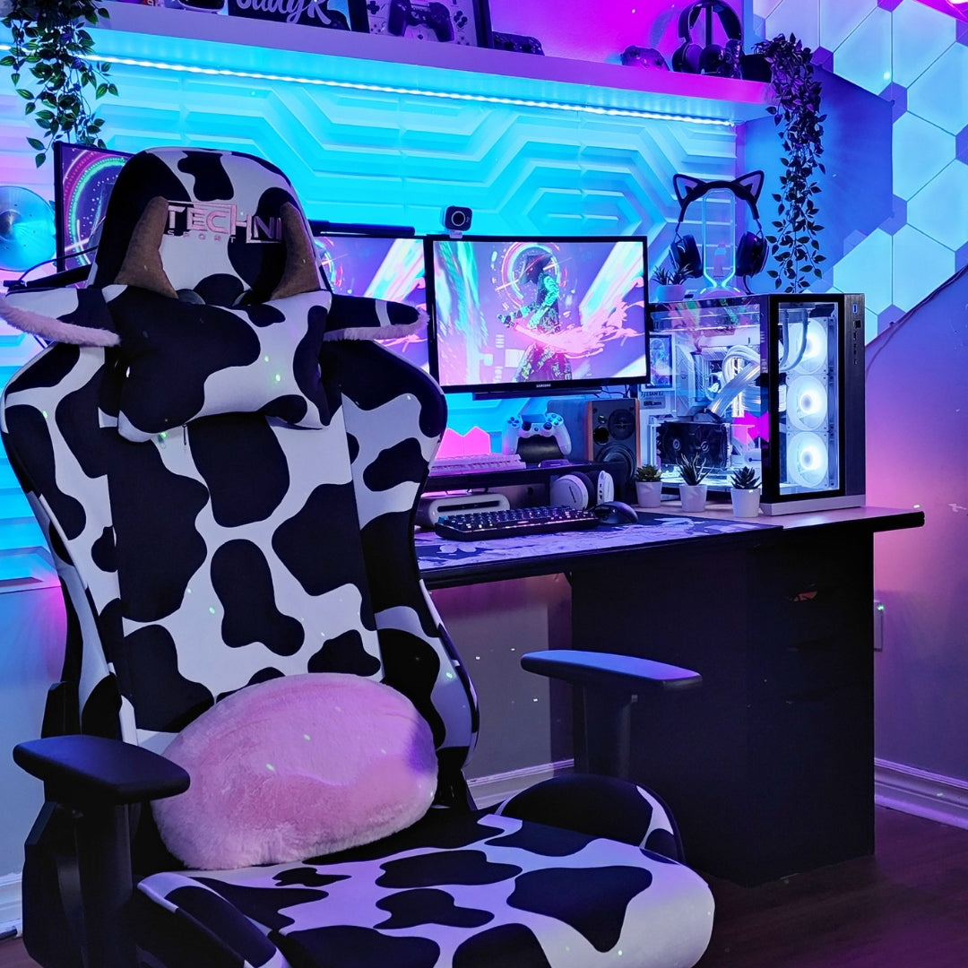 Cool gaming setup with LED lights and cow print gaming chair. 
