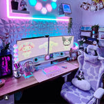Cute gaming setup with dual monitors, colorful lighting, and a comfortable cow gaming chair in a room. 