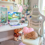 Home office setup with a desk, computer, and decorative items including plush toys and a rabbit. Features mint gaming chair 