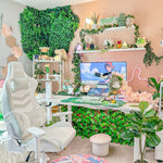 Cozy gaming space with plants, a mint gaming chair, and a computer setup. 