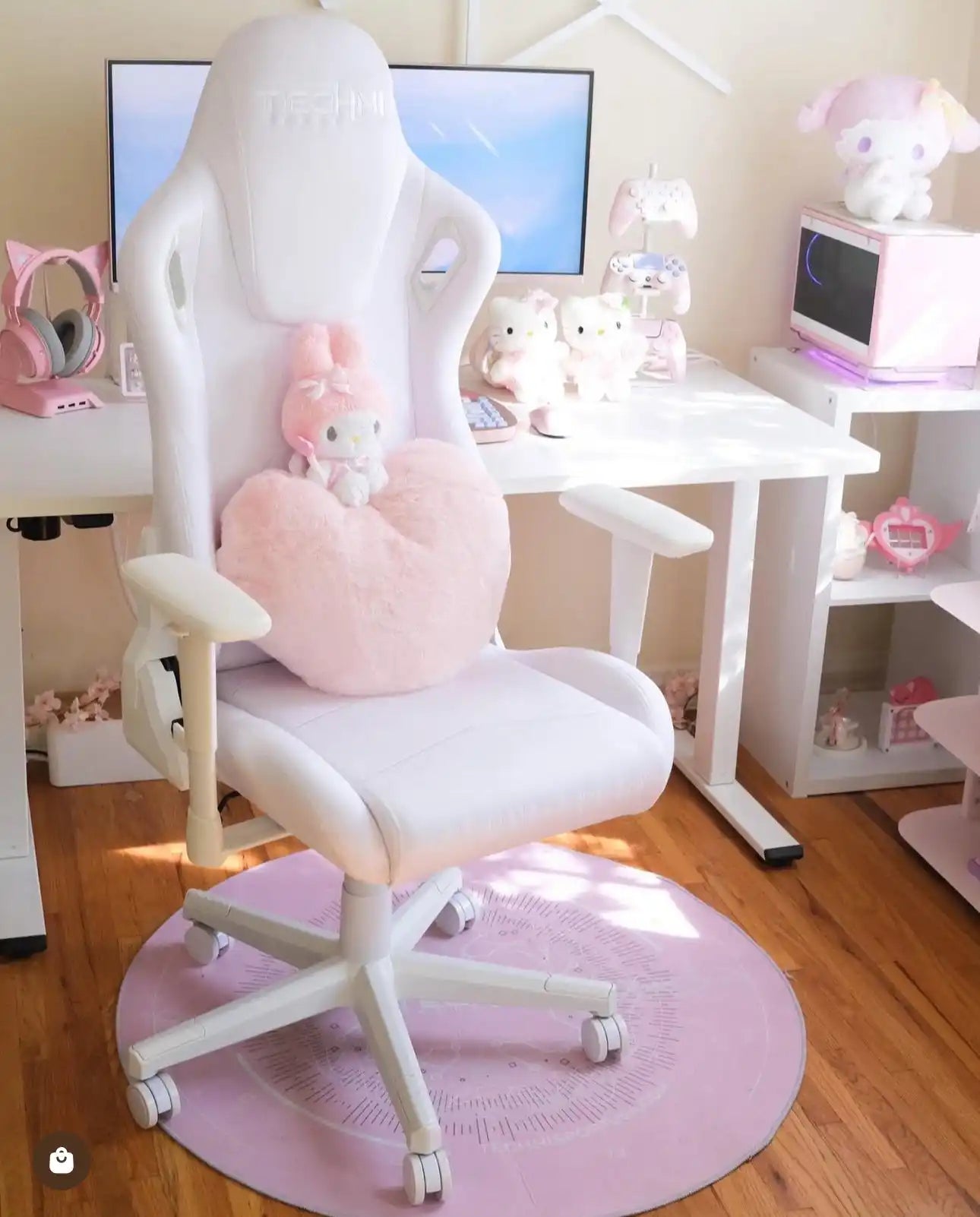 White gaming chair with a pink heart-shaped pillow and a small plush bunny.